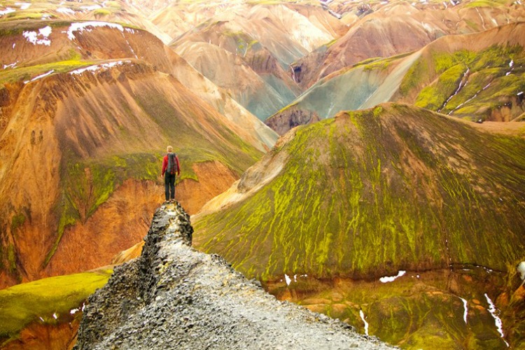 Iceland, Landmannalaugar region, climber on volcanic rock, rear view